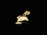 a close up of a gold dolphin pendant on a black background
