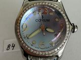 the watch is silver and has a brown leather band