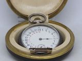 a pocket watch inside of a case on a white surface