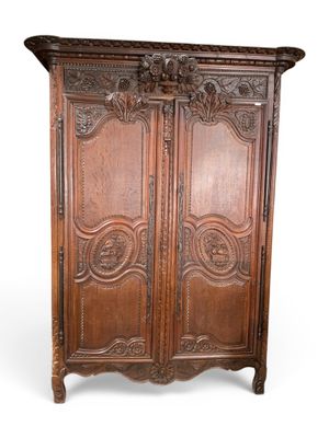 une vieille armoire en bois avec des gravures et des sculptures sur les portes