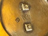 a close up of a metal plate with a button on it