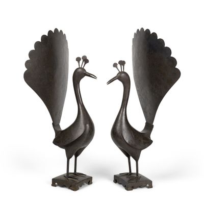 une paire de sculptures en bronze représentant des paons, posées sur des socles, sur fond blanc