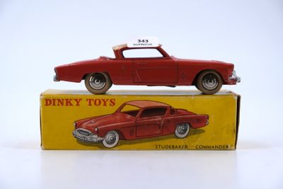 a red toy car sitting on top of a box