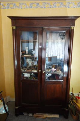 a wooden cabinet with a glass door in a room