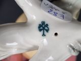 someone is holding a white porcelain figurine with a shamrock on it