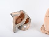 two clay figurines sitting next to each other on a white surface