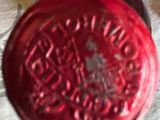 a close up of a red wax seal on a piece of paper