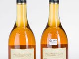 deux bouteilles de vin posées l'une à côté de l'autre sur une surface blanche