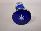 a small blue glass bottle with a star on it