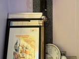 a picture of a clock and a picture on a shelf