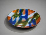 a plate with a colorful design on it sitting on a table