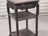 une petite table surmontée d'une étagère, placée devant une porte de garage