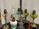 de nombreux types de lampes en verre posées sur une table noire