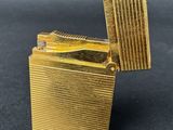 a close up of a gold lighter on a black surface
