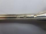 a close up of a silver spoon on a white surface