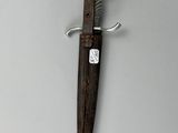 a knife hanging on the wall with a tag on it