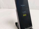 the back of a black cell phone sitting on top of a white table