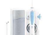 une brosse à dents avec, à côté, un tube de dentifrice et un distributeur de dentifrice