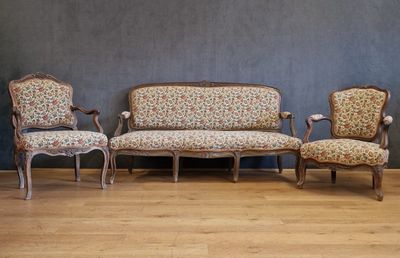 trois chaises et un canapé dans une pièce, avec un mur en arrière-plan