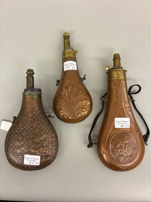 three antique brass bottle shaped vases on display on a white surface
