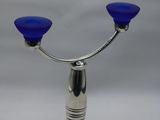 a blue glass candle holder on a metal stand
