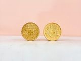 a pair of gold coins sitting on top of a white surface