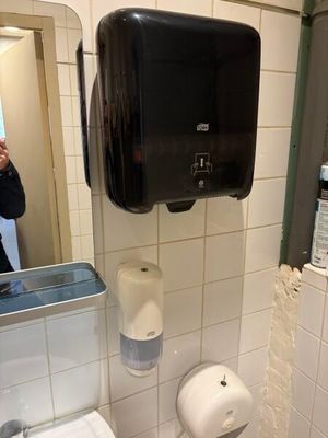 un homme en train de prendre une photo de toilettes dans des sanitaires publics