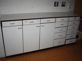 une armoire blanche avec des tiroirs dans une pièce