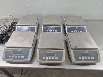 quatre balances électroniques posées sur une table dans une pièce