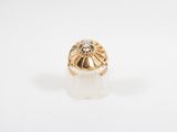 a close up of a gold ring with a diamond in the center