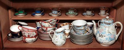 de nombreuses tasses et soucoupes posées sur une étagère dans un placard
