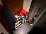 an image of a cluttered room with a chair and bookshelf