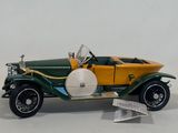 a green and yellow model of a car on a white surface