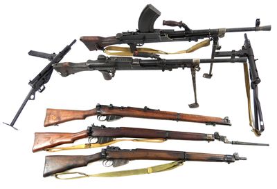 several different types of guns are lined up on a white surface