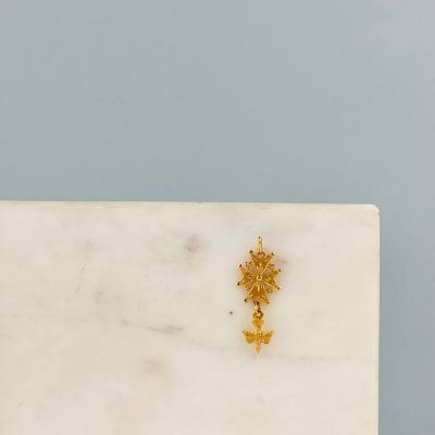 a close up of a white marble slab with a gold cross on it
