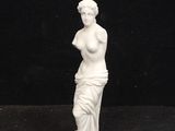 statue of a woman holding a vase on a black background