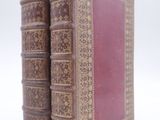 two old books that are sitting on a white surface