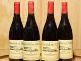 trois bouteilles de vin sont alignées sur un tonneau en bois