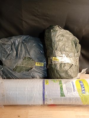deux sacs de provisions et un rouleau de film plastique par terre