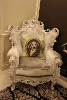 une chaise blanche avec un coussin posé dessus, dans un coin de la pièce