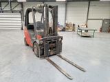 a forklift in a warehouse with pallets in the foreground