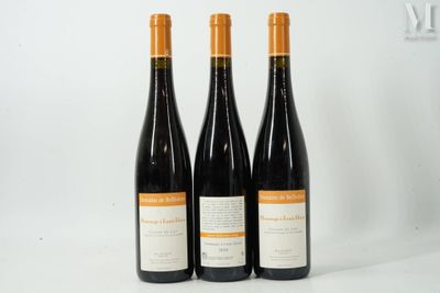 trois bouteilles de vin posées les unes à côté des autres sur une surface blanche