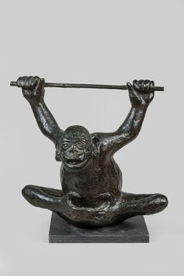 bronze sculpture of a monkey holding a bar on its back