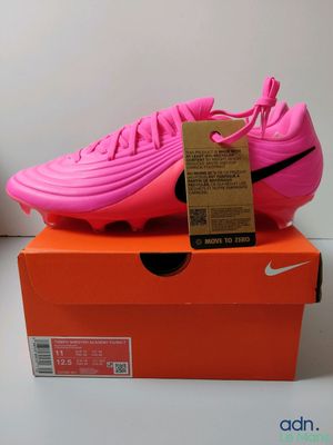 La chaussure de foot Nike Vapor rose est posée sur une boîte orange