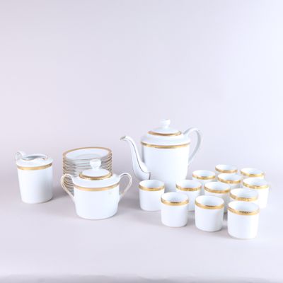 a white and gold tea set with cups and saucers