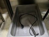 a metal sink with a hose in the middle of it