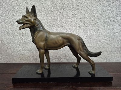 statue of a german shepherd dog on a black base on a table