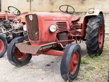 un tracteur rouge garé devant un bâtiment