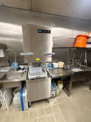 une cuisine avec de nombreux plans de travail en inox