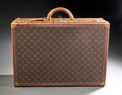 an old louis vuitton suitcase sitting on top of a table